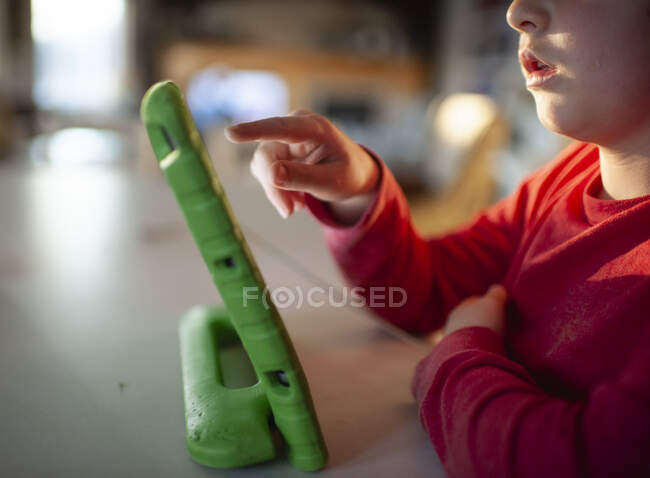 Close up de uma criança apontando para tablet eletrônico em casa — Fotografia de Stock