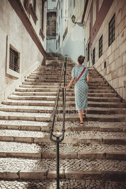 Woman climbing stairs through the streets of Lisbon — Stock Photo