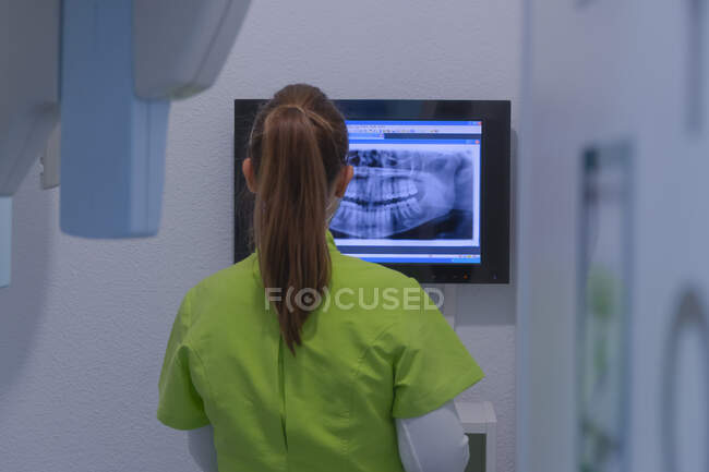 Mulher dentista diagnosticando uma radiografia na clínica dentária — Fotografia de Stock