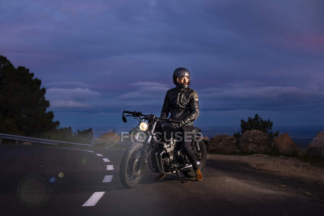 Мотоцикліст на своєму мотоциклі вночі на дорозі — стокове фото