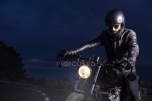 Motociclista sulla sua moto choper di notte sulla strada — Foto stock