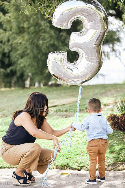 Mutter und ihr kleiner Junge mit einem Geburtstagsballon im Park — Stockfoto