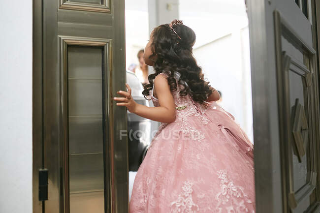 Menina esperando na porta para sua mãe em seu vestido de noiva — Fotografia de Stock