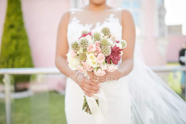 Mariée tenant un bouquet de fleurs — Photo de stock