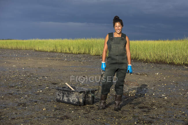 Jovem mulher colhendo ostras, frutos do mar — Fotografia de Stock