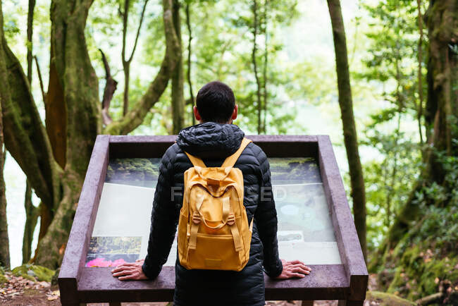 Young man looking up information of a viewpoint — Stock Photo