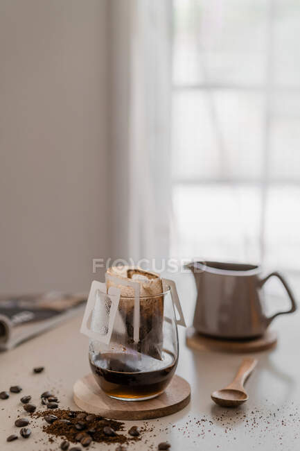 Máquina de café com uma xícara de chá e uma colher em uma mesa de madeira — Fotografia de Stock
