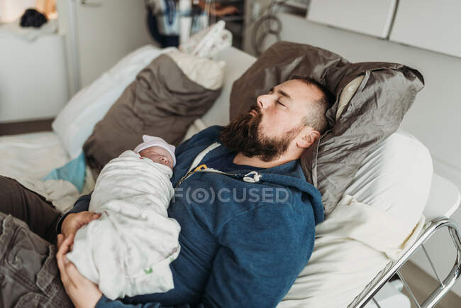 Content father resting after birth of newborn baby son — Stock Photo