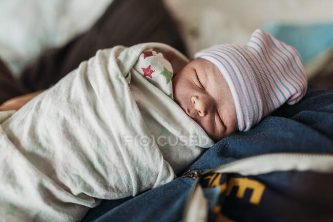 Gros plan du nouveau-né emmailloté dans le chapeau quelques minutes après la naissance — Photo de stock