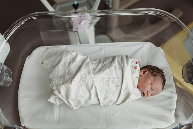Above angle view of newborn baby boy right after birth in basinett — Stock Photo