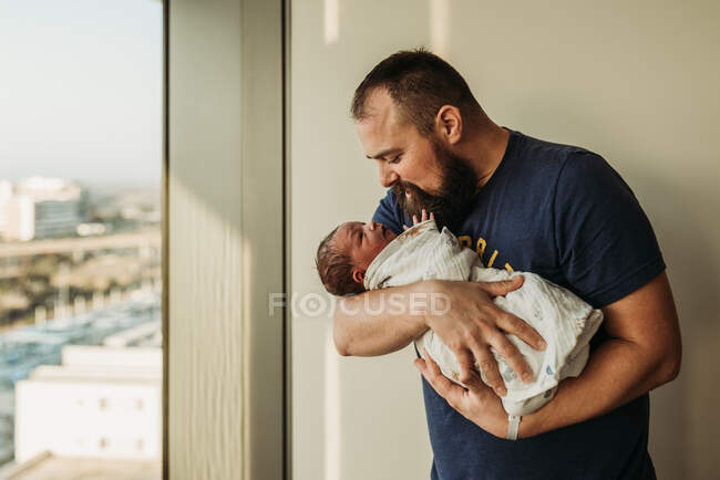 Lifestyle portrait of dad holding newborn baby boy in birthing center — Stock Photo