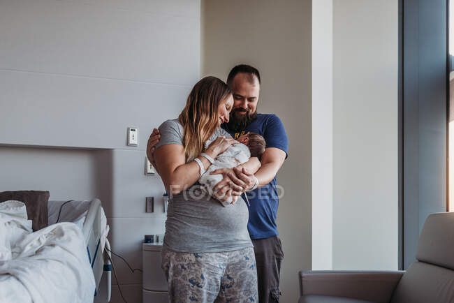 Newborn baby boy being cradled by new parents in birthing center — Stock Photo