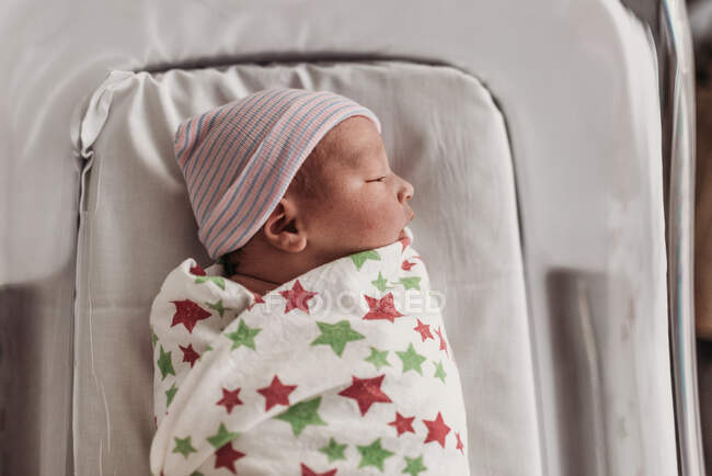 Swaddled newborn in hat at hospital — Stock Photo