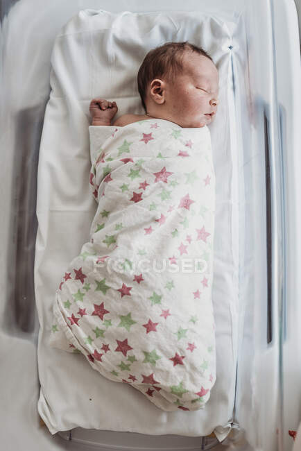 Niño recién nacido en moisés envuelto en manta de hospital - foto de stock