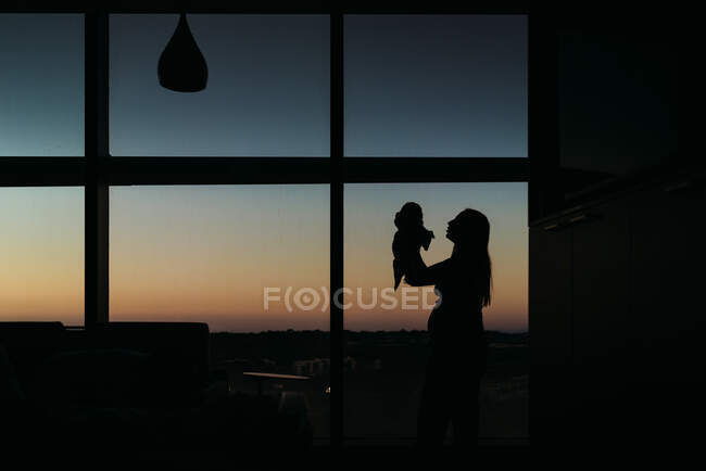 Silhouette of mother and newborn in hospital room — Stock Photo