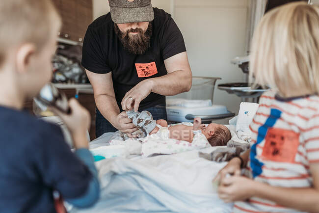 Vater bereitet neugeborenen Sohn auf Rückkehr aus Geburtszentrum vor — Stockfoto