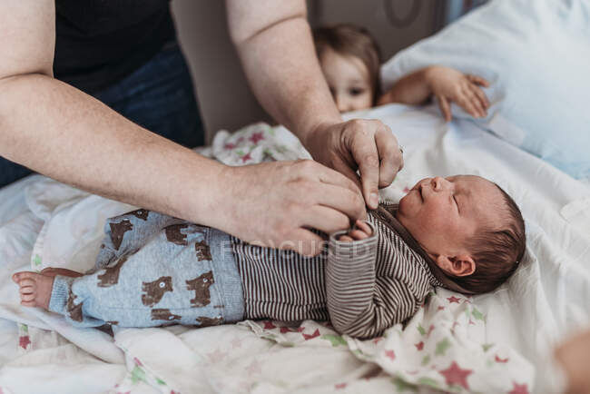 Vater kleidet neugeborenen Sohn aus Geburtszentrum nach Hause — Stockfoto