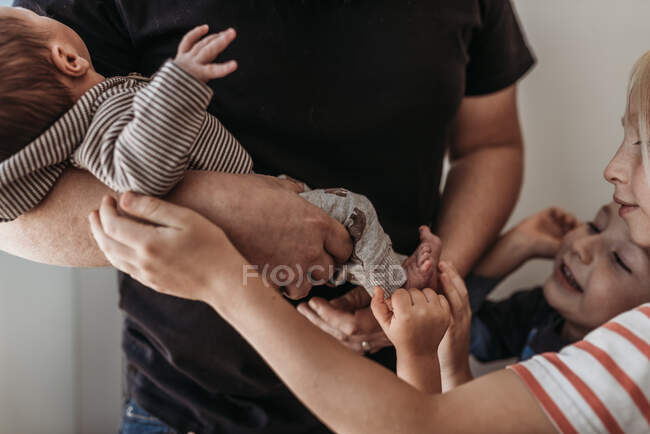 Крупним планом брати і сестри торкаються новонародженого брата в лікарні — стокове фото