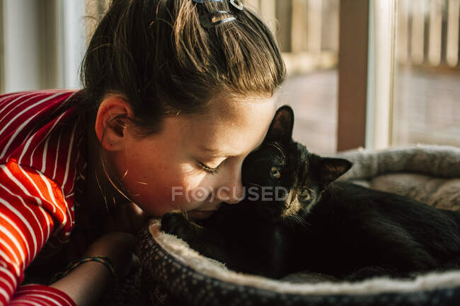 Close up di una ragazza coccole con il suo gattino nero — Foto stock