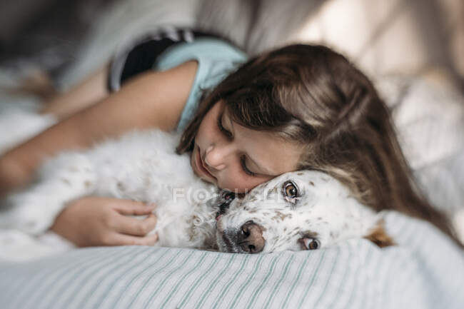 Ragazza abbracciando il suo cane inglese Setter alla luce del sole del mattino — Foto stock