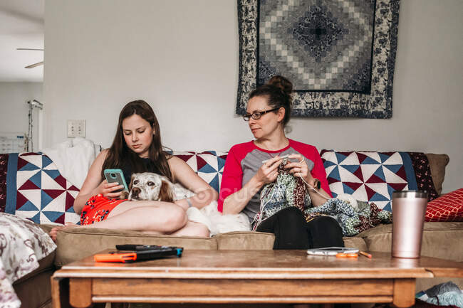 Mutter und Tochter sitzen auf der Couch und schauen aufs Handy — Stockfoto
