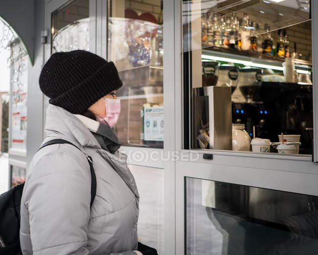 Chica en una chaqueta de invierno tomando café - foto de stock