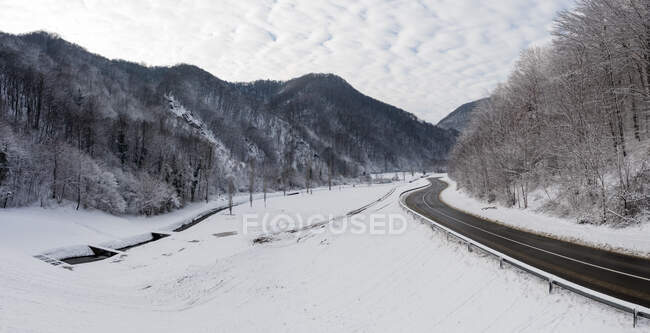 Vista aerea panoramica della strada che attraversa la copertura del paesaggio con neve fresca, Croazia. — Foto stock