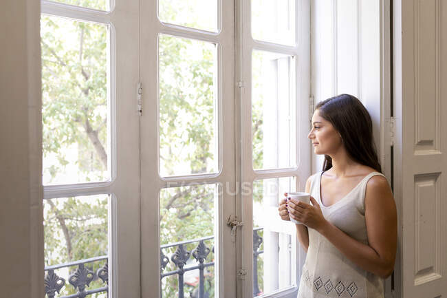 Beautiful young woman drinking coffee in the morning — Stock Photo
