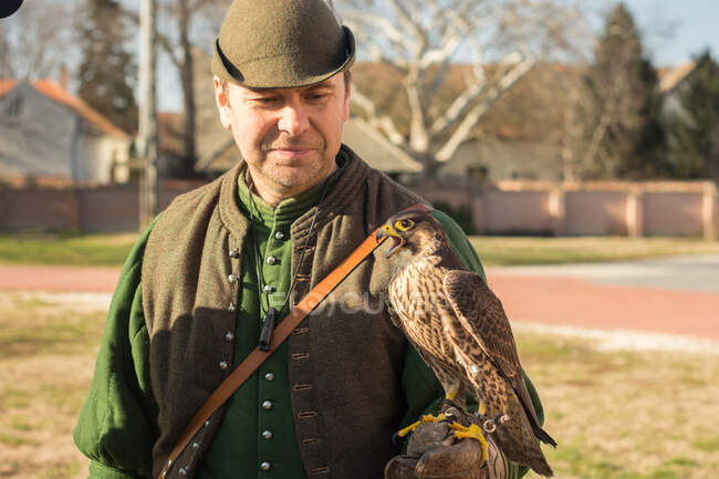 Cacciatore maschio con uccello rapace a portata di mano — Foto stock