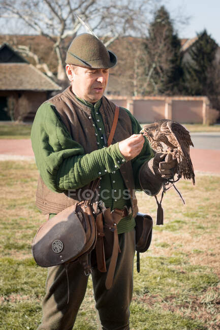 Homem caçador alimentando um falcão — Fotografia de Stock