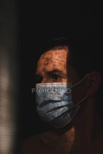 Uomo con maschera nell'ombra, protezione covid — Foto stock