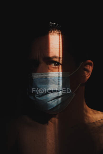 Mann mit Maske im Schatten, verdeckter Schutz — Stockfoto
