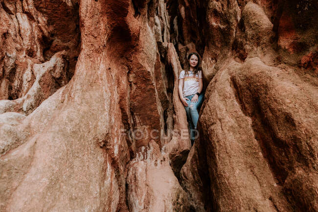 Preteen girl climbing on rocks on a warm day — Stock Photo