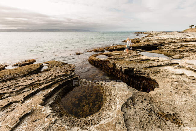 Tween menina walkin em rochas perto do oceano na Nova Zelândia — Fotografia de Stock