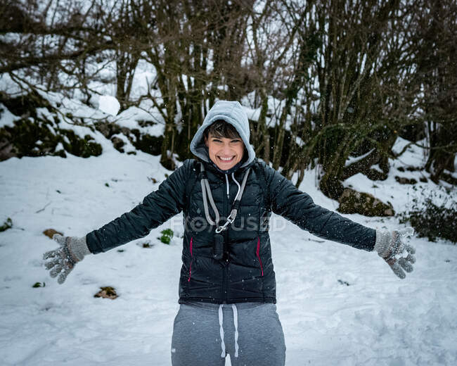 Junge Frau im Schnee lächelt beim Spielen — Stockfoto