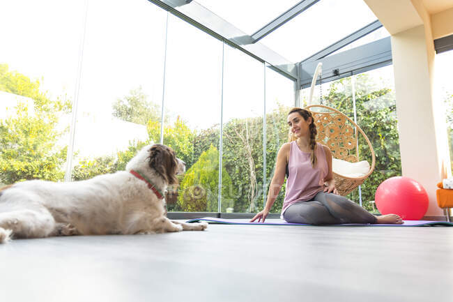 Frau mit Hund entspannt sich im Fitnessstudio — Stockfoto