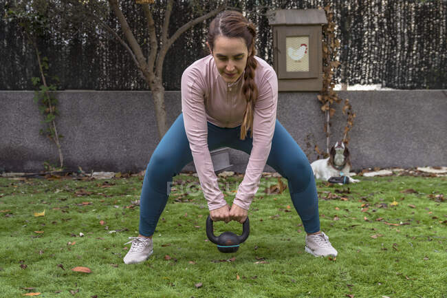 Jeune femme en vêtements de sport faire des exercices à l'extérieur. — Photo de stock
