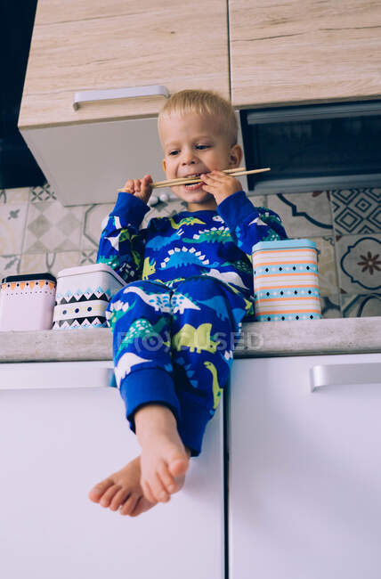 A criança brinca na cozinha pela manhã — Fotografia de Stock