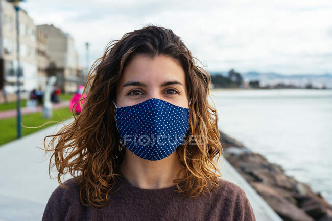 Jovem mulher na rua usando uma máscara facial — Fotografia de Stock