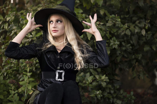 Jeune femme en chapeau de sorcière à l'extérieur — Photo de stock