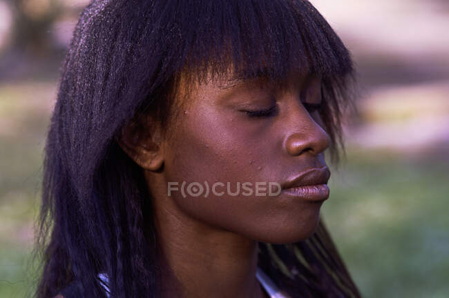 Retrato de una hermosa joven mujer de piel negra con los ojos cerrados - foto de stock