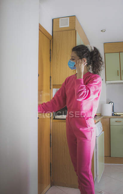 Mujer joven en máscara médica en casa - foto de stock