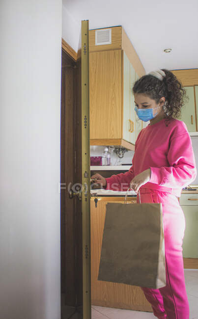 Young woman in medical mask at home — Stock Photo