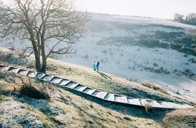 Two kids stood on top of a big hill in the countryside in England — Stock Photo