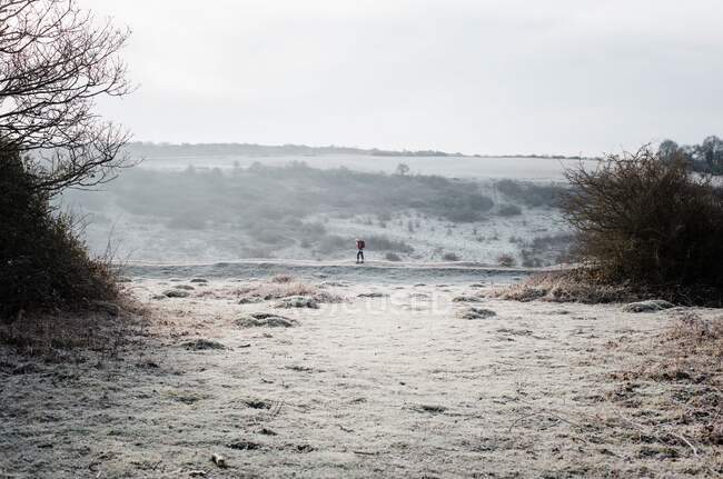 Mulher andando ao longo de um caminho gelado no campo Inglês no inverno — Fotografia de Stock