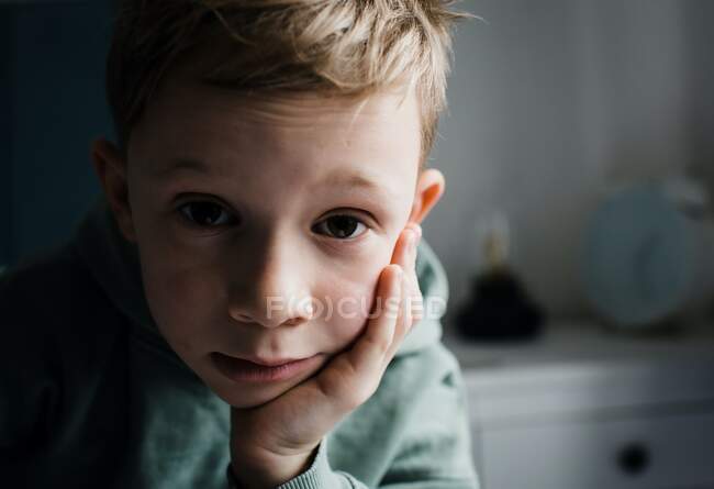 Menino de 8 anos de idade olhando cansado, pensativo e expressivo em casa — Fotografia de Stock