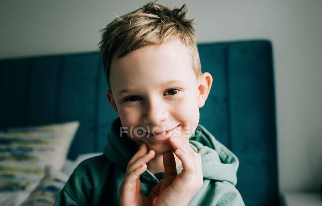 Portrait of an 8 year old handsome boy smiling playfully at home — Stock Photo