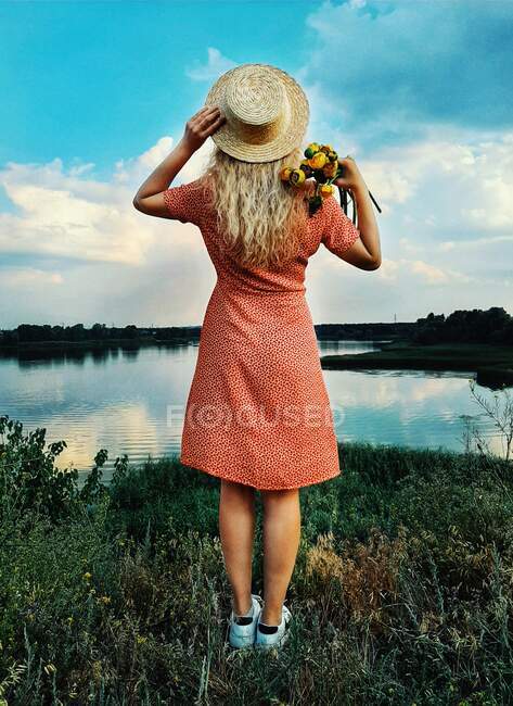 Primer plano de una joven con vestido de verano con flores y earrin - foto de stock