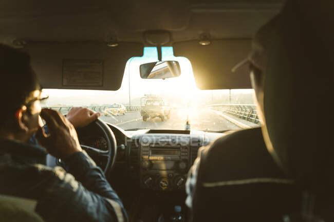 Two engineers inside a car going to work in the sunrise — Stock Photo