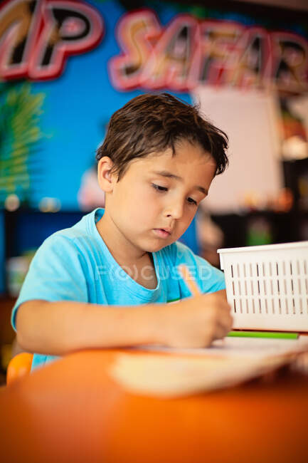 Boy drawing in a very colorful room. — Stock Photo